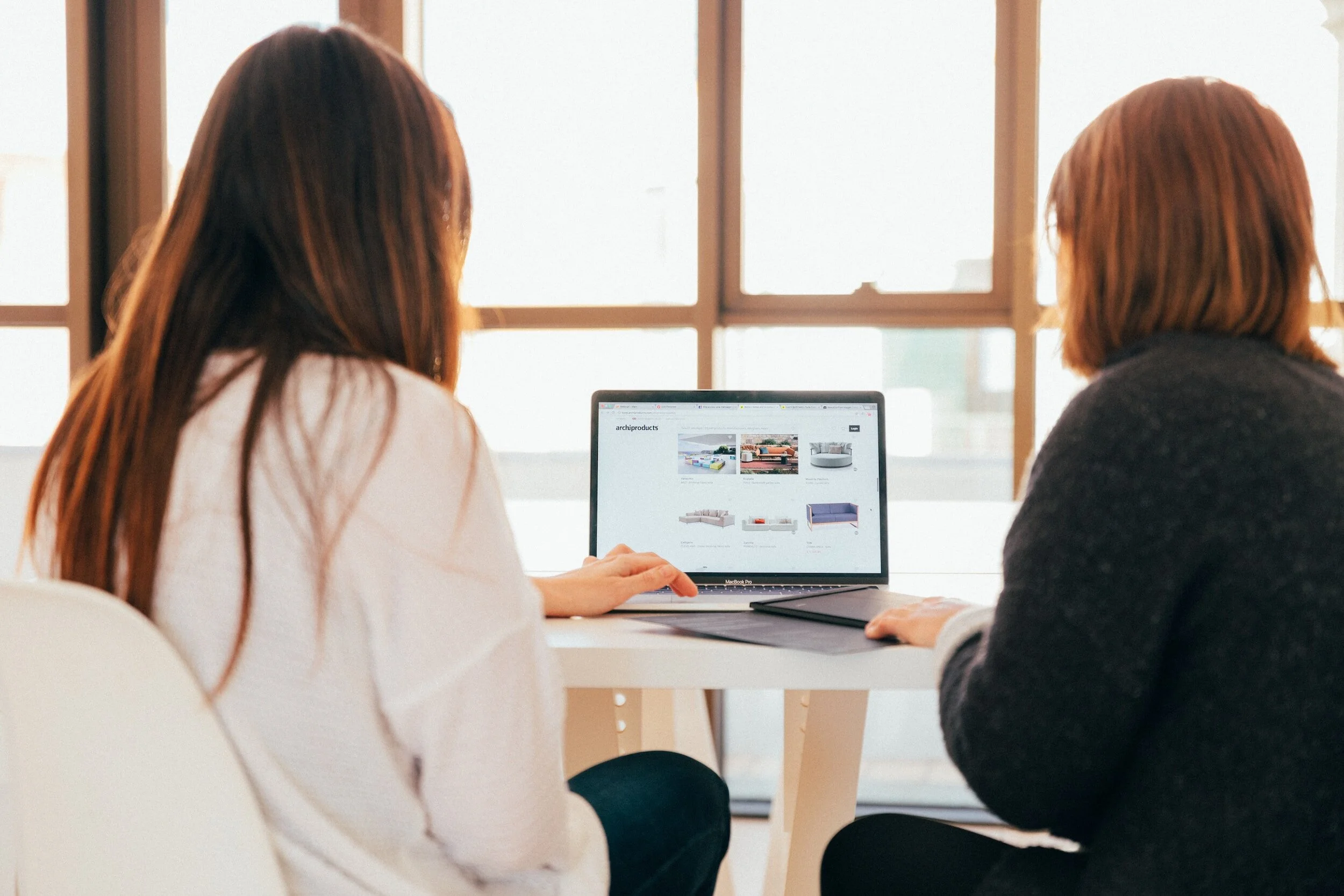 Two women looking at a computer together