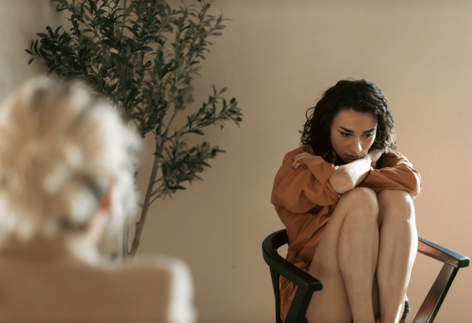 a woman sitting in a chair engaging in therapy for trauma and PTSD