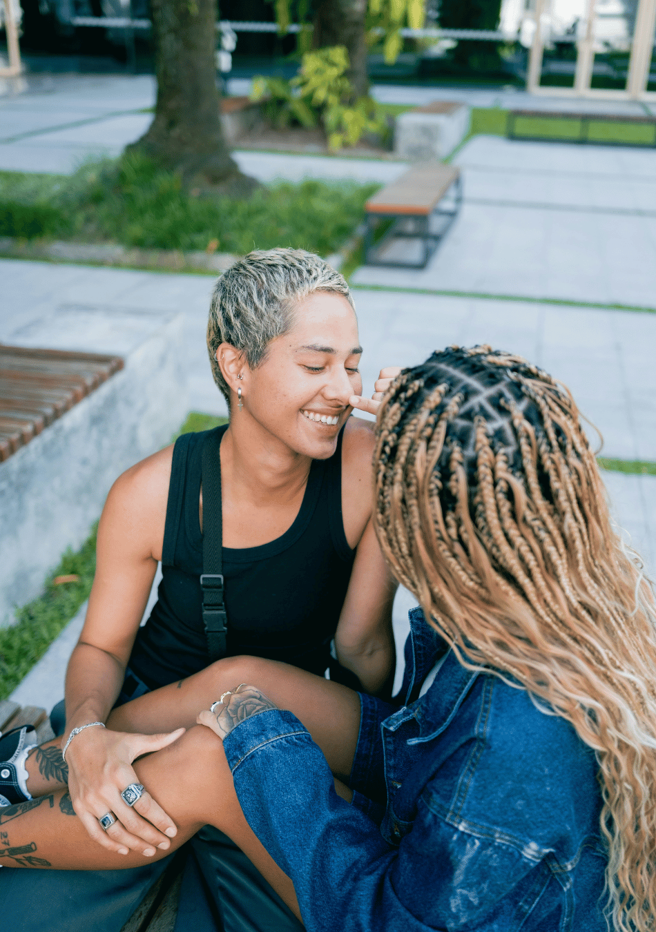 two partners smiling warmly at each other on a park bench to illustrate dating tips for your 30s