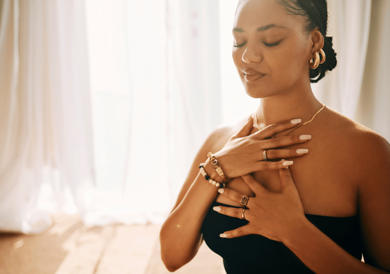 a woman meditating and breathing with her hands on her chest illustrating how to develop a secure attachment style as an adult