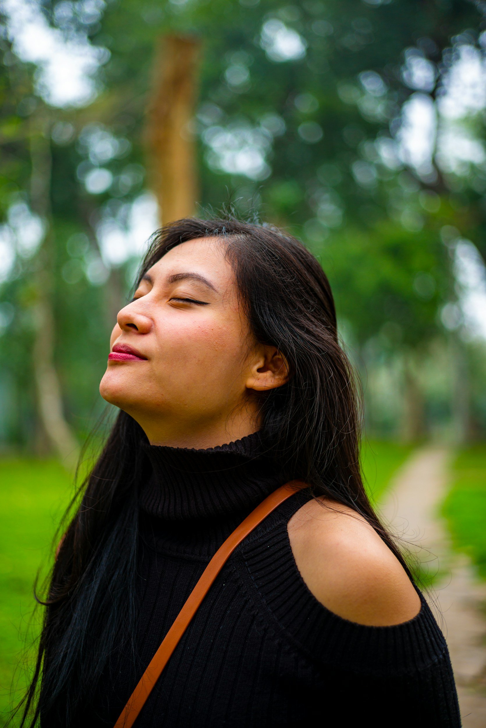 how to break generational trauma a young woman closing her eyes looking up peacefully